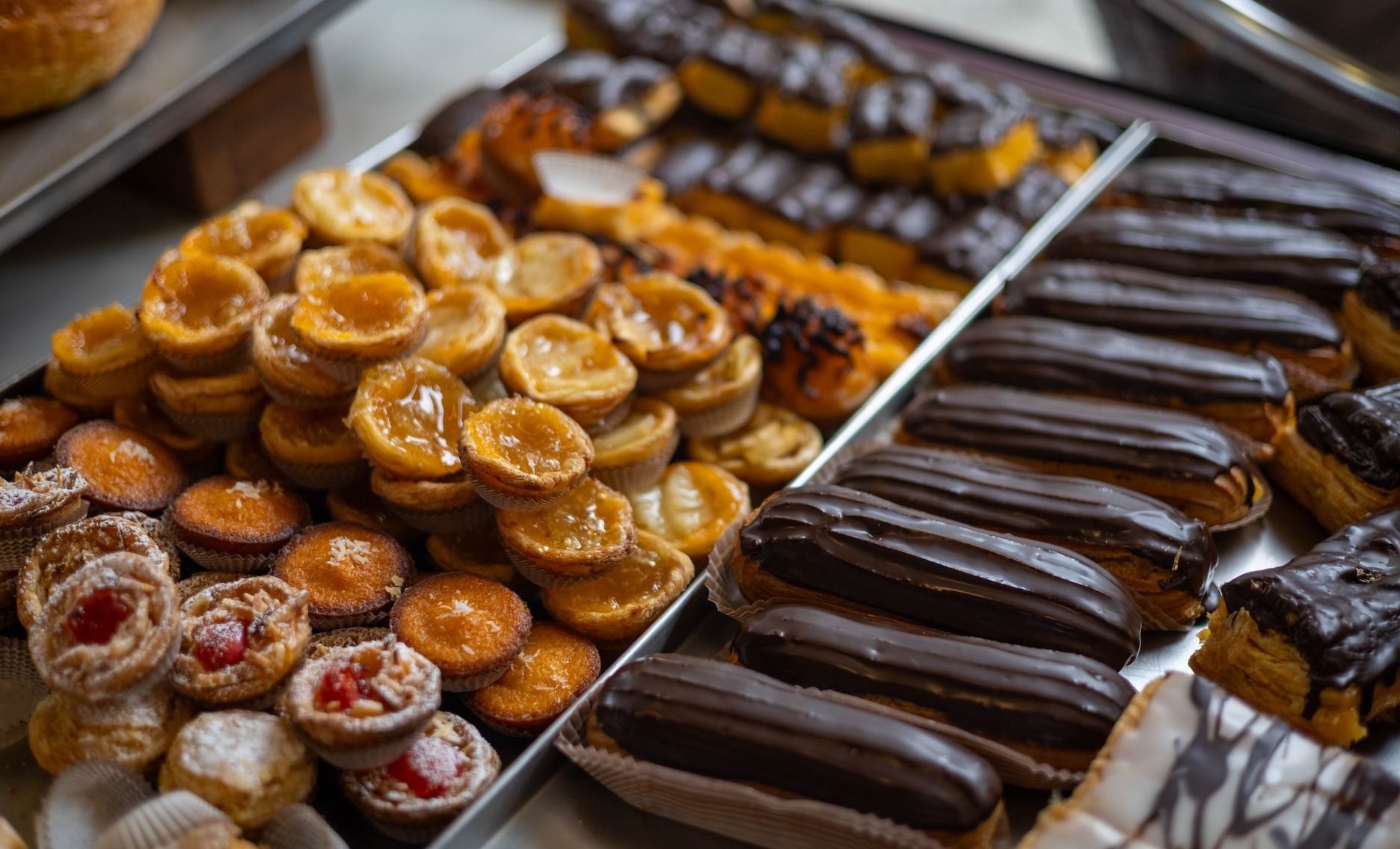 pastelaria variada como eclairs, natas e delícias